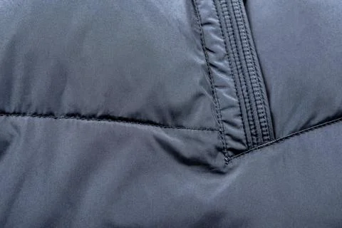 Texture of black warm down jacket as background, close-up. Cold weather clo.. Stock Photos