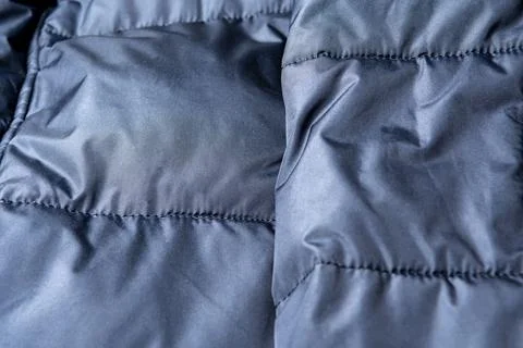 Texture of black warm down jacket as background, close-up. Cold weather clo.. Stock Photos