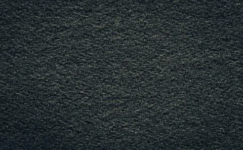 Texture of black woolen or dark tweed fabric close-up. Stock Photos