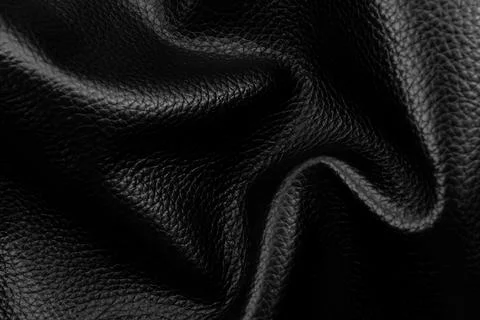 Texture of black wrinkled leather. Background of genuine leather with creas.. Stock Photos