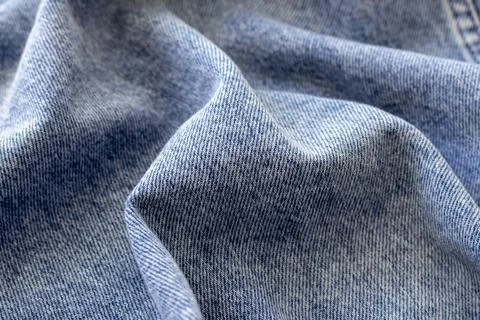 The texture of blue denim folded in waves in close-up Stock Photos