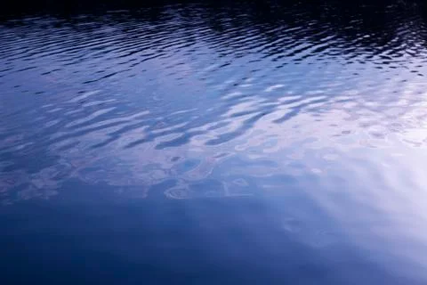 Texture of blue river water in the evening illumination Stock Photos