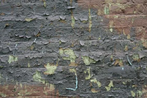Texture of a brick wall with peeling paint from it. Abstract building backgro Fotos de archivo