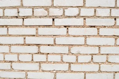 Texture of a brick wall with rectangular beige bricks of different sizes with Stock Photos