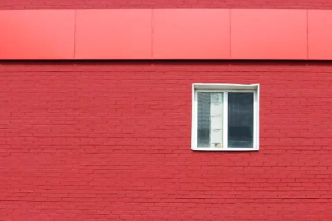 The texture of bright red brick wall with canopy and white window on a sunny day Stock Photos