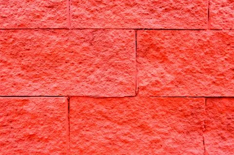 Texture of bright red large large rectangular convex stone bricks. The backgr Stock Photos