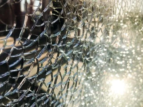 The texture of the broken cracked thick fragile broken sharp glass, triplex w Stock Photos