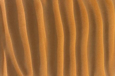 Texture brown desert sand with vertical deep dunes. Stock Photos