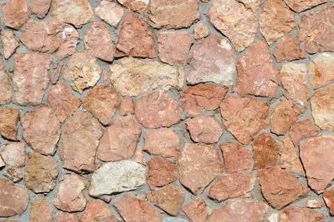 Texture in brown tones. Wall made of natural natural stone granite and sandst Stock Photos