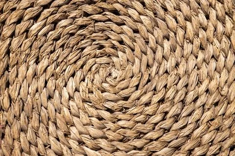 Texture with a circular pattern made with braided palm leaves. Stock Photos