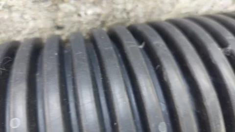 Texture close up of black flexible corrugated plastic pipe surface 動画素材 346304943
