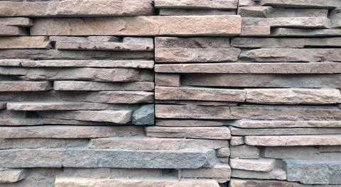 The texture is close to the wall consisting of stones bricks of different colors Stock Photos