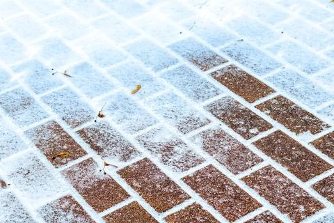 The texture of the cobblestone path covered with the first snow in winter. Foto stock