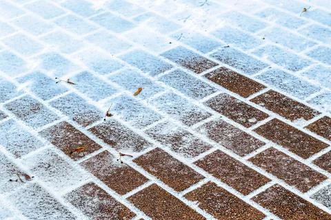 The texture of the cobblestone path covered with the first snow in winter. Foto stock