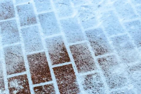 The texture of the cobblestone path covered with the first snow in winter. 스톡 사진