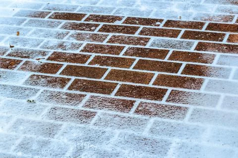 The texture of the cobblestone path covered with the first snow in winter. Foto stock