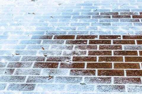 The texture of the cobblestone path covered with the first snow in winter. Foto stock