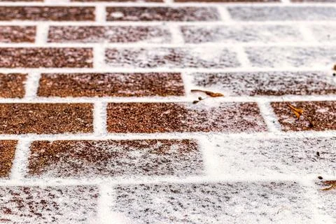 The texture of the cobblestone path covered with the first snow in winter. Foto stock