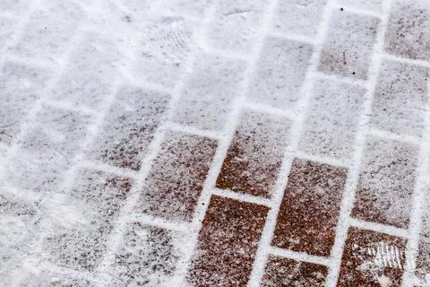 The texture of the cobblestone path covered with the first snow in winter. Foto stock