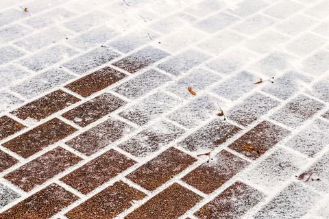 The texture of the cobblestone path covered with the first snow in winter. Foto stock