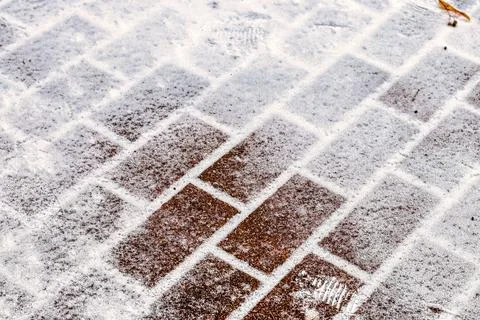 The texture of the cobblestone path covered with the first snow in winter. Foto stock