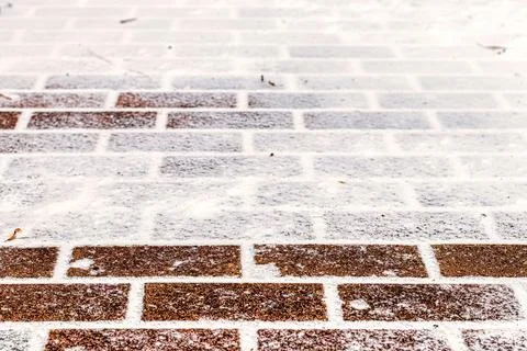 The texture of the cobblestone path covered with the first snow in winter. Foto stock