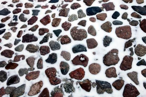 Texture of cobblestone pavement after snowfall. Stock Photos