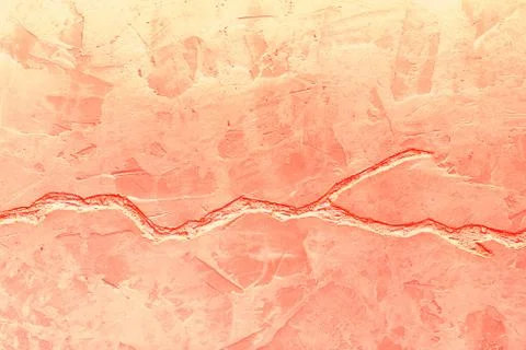 Texture of a concrete wall with a deep crack of coral color. Stock Photos