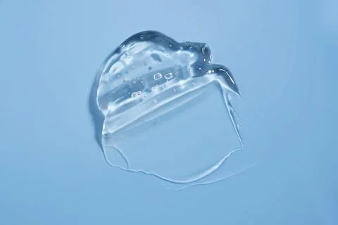 The texture of a cosmetic gel on a blue background. Stock Photos