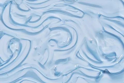 The texture of the cosmetic gel on the blue background. Stock Photos