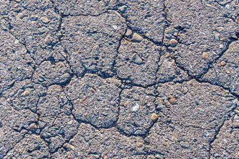 Texture of cracked old road surface, background of old asphalt road or sidewalk Foto stock