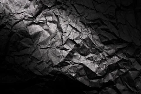 Texture of crumpled black paper with gradient. Dark paper background with w.. Foto stock