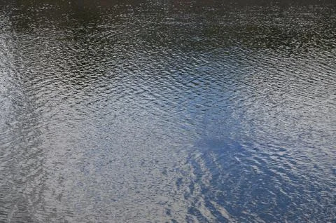 The texture of dark river water under the influence of wind, imprinted in per Stock Photos