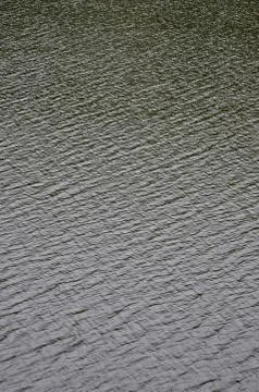 The texture of dark river water under the influence of wind, imprinted in per Stock Photos