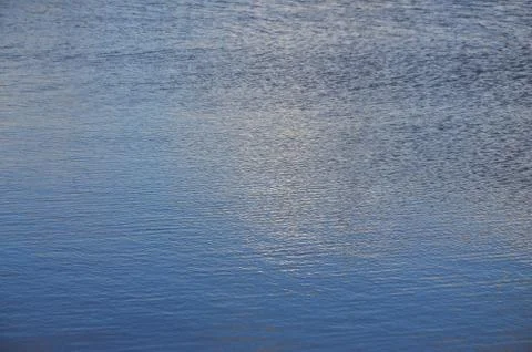 The texture of dark river water under the influence of wind, imprinted in per Stock Photos