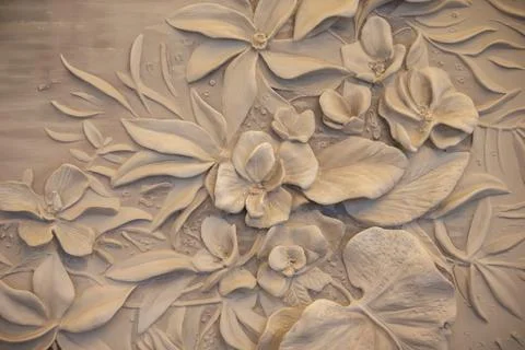 Texture of a decorative wall panel with flowers made of concrete and plaster. Stock Photos
