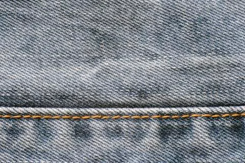 Texture of denim, seam of yellow thread, background Stock Photos