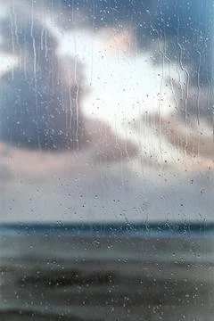 The texture of the drops on the window glass. Beach and sea on a blurred ba.. Stock Photos