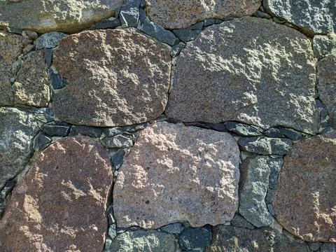 Texture of the facade of a building made of old stones Stock Photos