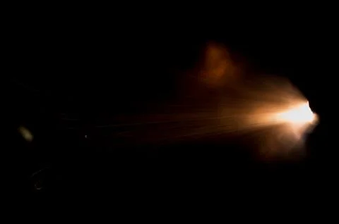 The texture of a firearm shot , a bright flash of flame on a black background Stock Photos