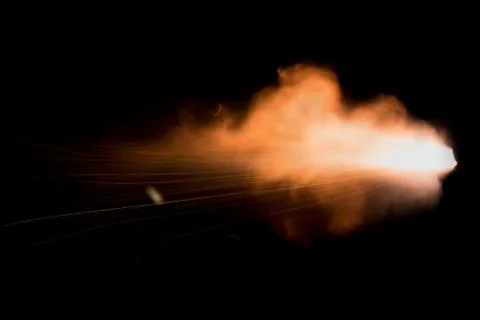 The texture of a firearm shot , a bright flash of flame on a black background Stock Photos