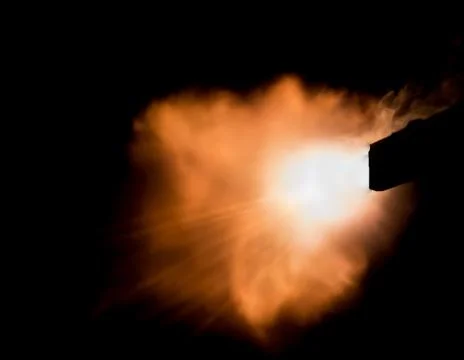 The texture of a firearm shot , a bright flash of flame on a black background Foto stock