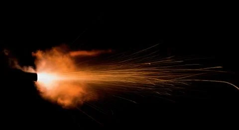 The texture of a firearm shot , a bright flash of flame on a black background Stock Photos