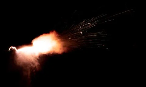 The texture of a firearm shot , a bright flash of flame on a black background Stock Photos