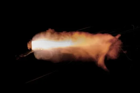 The texture of a firearm shot , a bright flash of flame on a black background Stock Photos