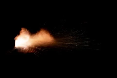 The texture of a firearm shot , a bright flash of flame on a black background Stock Photos