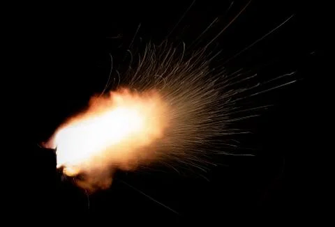 The texture of a firearm shot , a bright flash of flame on a black background Stock Photos