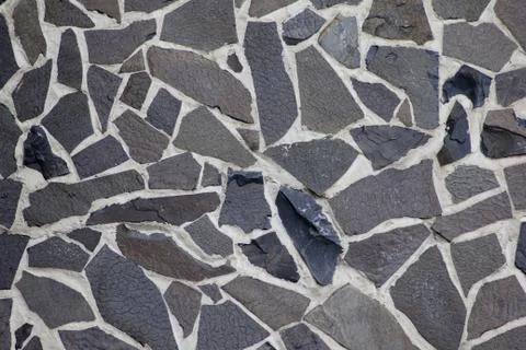 Texture of flat granite blocks of different sizes of dark color. Stock Photos