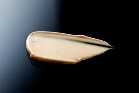 The texture of a foundation liquid. Black background. Stock Photos