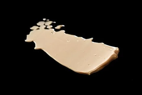 The texture of a foundation liquid. Black background. Stock Photos